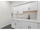 Laundry room with white cabinets and a utility sink at 1369 Burt Ave, Berthoud, CO 80513