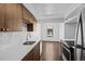 Clean kitchen features white countertops, wood cabinets, tile backsplash, and stainless sink at 7665 E Eastman Ave # D304, Denver, CO 80231