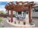 Backyard patio with a pergola, outdoor furniture, grill, and flowers at 13093 Hudson St, Thornton, CO 80241