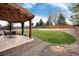 Manicured backyard with pergola, patio, grass, and walkway at 13093 Hudson St, Thornton, CO 80241