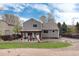 Home exterior featuring a covered patio, gravel landscaping, and a small patch of grass at 13093 Hudson St, Thornton, CO 80241