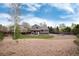Backyard view showcasing a house, covered patio, gravel, and small lawn at 13093 Hudson St, Thornton, CO 80241