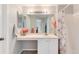 Bright bathroom with a large mirror, a white vanity, and a shower with a floral curtain at 13093 Hudson St, Thornton, CO 80241