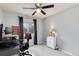 Bedroom with a ceiling fan, window with dark curtains, desk, and cabinet at 13093 Hudson St, Thornton, CO 80241