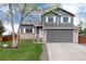 Charming two-story home features a well-maintained lawn and a classic gray exterior with brick accents at 13093 Hudson St, Thornton, CO 80241