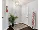 Inviting foyer with dark wood flooring, a 'Welcome' sign, a decorative light fixture, and a potted plant at 13093 Hudson St, Thornton, CO 80241