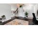 Bright foyer area featuring a staircase, dark wood flooring, and a view into an adjacent room at 13093 Hudson St, Thornton, CO 80241