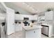 Bright kitchen features white cabinets, stainless steel appliances, and a vaulted ceiling with modern track lighting at 13093 Hudson St, Thornton, CO 80241