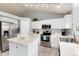 Updated kitchen boasts stainless steel appliances, white cabinetry, and a convenient center island for food preparation at 13093 Hudson St, Thornton, CO 80241