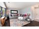 Spacious living room featuring a comfortable gray sofa, colorful rug, and dark hardwood flooring at 13093 Hudson St, Thornton, CO 80241