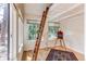 Bright bedroom with decorative ladder, hardwood floors, artist's easel, and abundant natural light at 4878 E Kentucky Ave # A, Denver, CO 80246