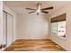This bedroom features hardwood flooring, a large window, and a ceiling fan at 4878 E Kentucky Ave # A, Denver, CO 80246