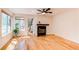 Spacious living room with a ceiling fan, fireplace, wood floors, and natural light from large windows at 4878 E Kentucky Ave # A, Denver, CO 80246