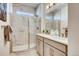 Modern bathroom featuring a glass-enclosed shower with stylish tile and double vanity sinks at 13806 Honey Hush Trl, Parker, CO 80134