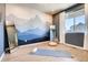 Bright bedroom with mountain mural wall, wood floors, and large window, perfect for relaxing at 13806 Honey Hush Trl, Parker, CO 80134