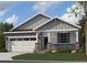 Charming single-story home with stone accents, gray siding, a two-car garage, and manicured front yard at 13806 Honey Hush Trl, Parker, CO 80134