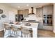 Modern kitchen featuring a large island, stainless steel appliances, gray cabinets, and stylish bar stools at 13806 Honey Hush Trl, Parker, CO 80134