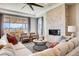 Cozy living room featuring a stone fireplace, plush seating, large windows, and stylish modern décor at 13806 Honey Hush Trl, Parker, CO 80134