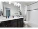 Well-lit bathroom with double sinks, modern fixtures, tiled shower and backsplash, and sleek design at 15565 E 115Th Ave, Commerce City, CO 80022