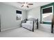 Bright bedroom features a decorative wrought iron daybed, two windows with coverings, and clean and modern design at 15565 E 115Th Ave, Commerce City, CO 80022