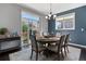 Cozy dining area with a round table, seating for six, and abundant natural light from the sliding glass door at 15565 E 115Th Ave, Commerce City, CO 80022