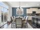 Dining area open to the kitchen features a round table, seating for six, and a stylish blue accent wall at 15565 E 115Th Ave, Commerce City, CO 80022