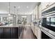 Open kitchen boasts a large island, stainless steel appliances, and dining area views at 15565 E 115Th Ave, Commerce City, CO 80022