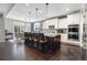 Modern kitchen with island and seating, flowing into the adjacent dining area at 15565 E 115Th Ave, Commerce City, CO 80022