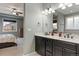 Main bathroom with double vanity, granite countertop, and views of the bedroom for an open feel at 15565 E 115Th Ave, Commerce City, CO 80022