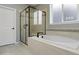 Luxurious main bathroom featuring a soaking tub, a separate glass-enclosed shower, and elegant tile work at 15565 E 115Th Ave, Commerce City, CO 80022