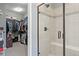 Walk-in closet with a glass-enclosed shower featuring built-in bench and elegant tile work at 15565 E 115Th Ave, Commerce City, CO 80022