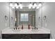 Main bathroom with double vanity, granite countertop, and a large mirror reflecting the luxurious tub and shower at 15565 E 115Th Ave, Commerce City, CO 80022
