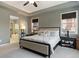 Spacious main bedroom with tray ceiling, neutral decor, large bed, and en-suite bathroom access at 15565 E 115Th Ave, Commerce City, CO 80022