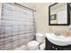 Bright bathroom features a vanity with a black cabinet, a toilet and a shower with a patterned curtain at 1173 Dallas St, Aurora, CO 80010