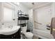 Bathroom features a vanity, toilet, and tiled shower with a patterned curtain at 1173 Dallas St, Aurora, CO 80010