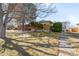 Exterior view of a well-kept home with a manicured lawn, walkway, and mature trees at 1173 Dallas St, Aurora, CO 80010
