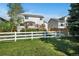 Backyard with a well-maintained lawn and a white fence under a clear blue sky at 5929 Dunraven Way, Golden, CO 80403
