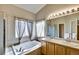 Bright bathroom featuring a soaking tub, double sinks, and a separate glass enclosed shower at 5929 Dunraven Way, Golden, CO 80403
