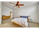 Bright bedroom featuring a bed, dresser, ceiling fan, and connecting bathroom at 5929 Dunraven Way, Golden, CO 80403