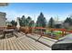 Wide shot of wood deck with table, chairs, and a grill, and trees in the background at 5929 Dunraven Way, Golden, CO 80403