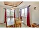 Inviting dining room with large windows, stylish curtains, a tray ceiling, and a modern pendant light fixture at 5929 Dunraven Way, Golden, CO 80403
