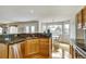 Kitchen with stainless steel appliances, granite countertops, light wood cabinets, and adjacent breakfast nook at 5929 Dunraven Way, Golden, CO 80403