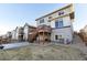 View of a backyard with a patio, a wooden deck with stairs, and a well-maintained lawn at 18809 W 92Nd Dr, Arvada, CO 80007