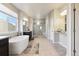 Bright bathroom showcasing a soaking tub, walk-in shower, double vanities, and modern fixtures at 18809 W 92Nd Dr, Arvada, CO 80007