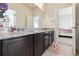 Well-appointed bathroom with dark wood cabinets, a vanity with granite countertops, and a decorative mirror at 18809 W 92Nd Dr, Arvada, CO 80007
