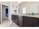 Bathroom showcasing granite countertops, dark wood cabinetry, and a decorative mirror at 18809 W 92Nd Dr, Arvada, CO 80007