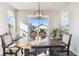 Well-lit dining room featuring a large wooden table and a modern light fixture at 18809 W 92Nd Dr, Arvada, CO 80007