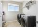 This laundry room features a large window, plenty of storage, and modern washer/dryer at 18809 W 92Nd Dr, Arvada, CO 80007