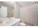 Clean bathroom with a white vanity, large mirror, and a shower with a decorative floral shower curtain at 8948 Delacorte St, Highlands Ranch, CO 80129