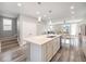 Bright, open-concept kitchen features a large island with sink, white cabinetry, and seamless flow to the living area at 8948 Delacorte St, Highlands Ranch, CO 80129